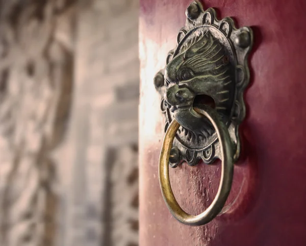 Ornate batedor porta de ouro na porta vermelha — Fotografia de Stock