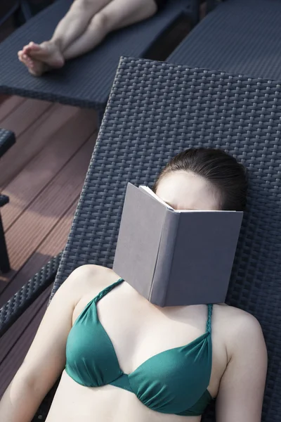 Femme relaxante avec un livre sur le visage — Photo