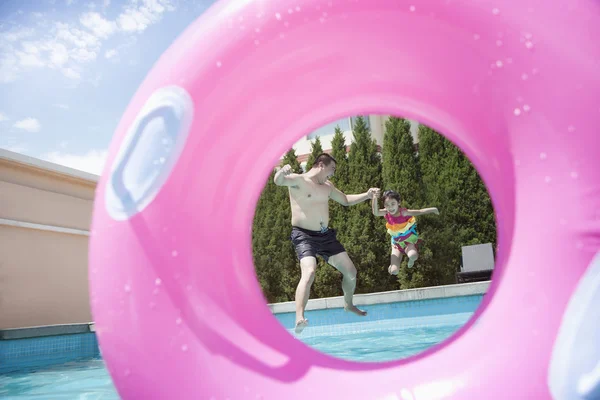 Vader en dochter springen in het zwembad — Stockfoto