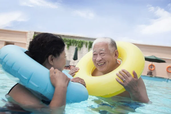 Casal sénior relaxante na piscina — Fotografia de Stock