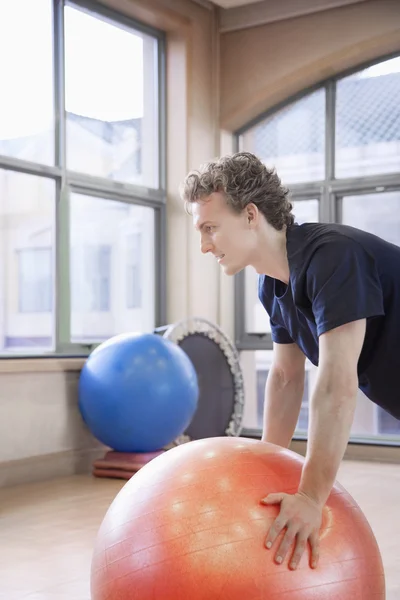 Man using a fitness ball to exercise — Stock Photo, Image