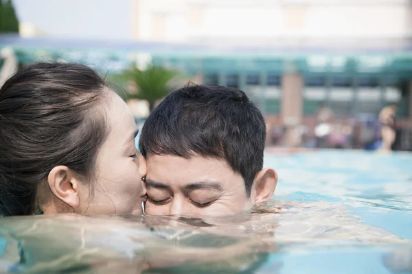 Mujer besándose hombre en la piscina —  Fotos de Stock