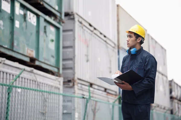 Worker examining cargo in a shipping yard — Stock Photo, Image