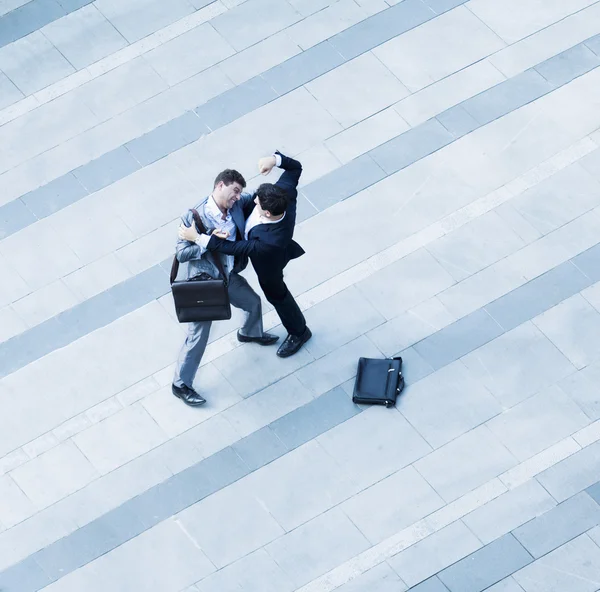 Affärsmän som slåss med varandra av trottoaren — Stockfoto