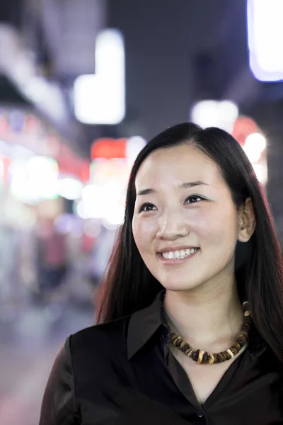 Smiling woman out at night in the city — Stock Photo, Image
