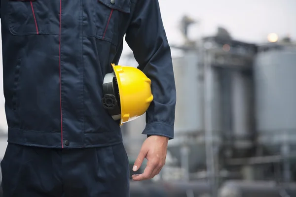 Worker holding a yellow hardhat — Stock Photo, Image