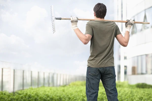 Man holding a rake on his shoulders — Stock Photo, Image