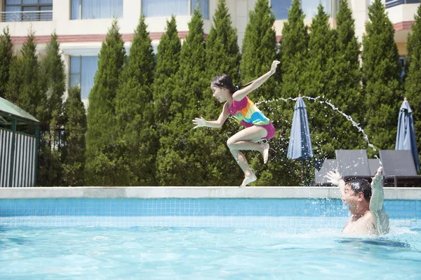 Padre lanzando a su hija a la piscina — Foto de Stock