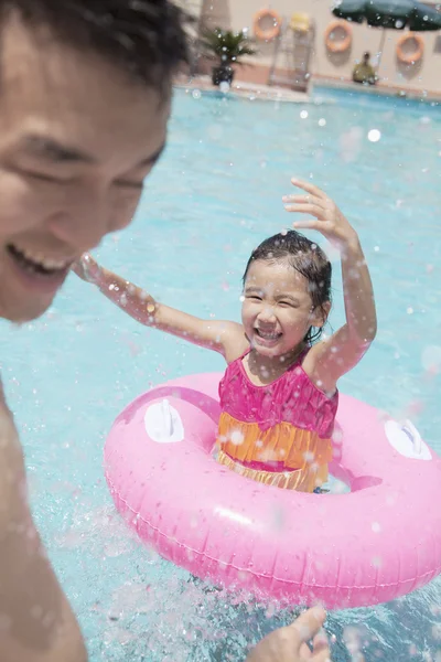 Chica y su padre salpicando en la piscina — Foto de Stock