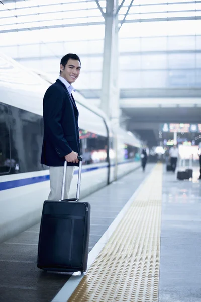 Homme d'affaires avec une valise sur la plate-forme ferroviaire — Photo