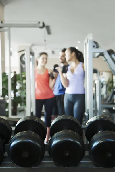 Three people lifting weights in the gym — Stock Photo, Image