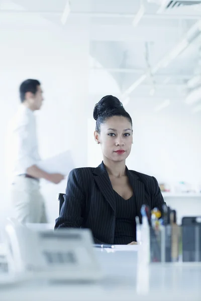 Empresaria sentada en su escritorio en la oficina — Foto de Stock