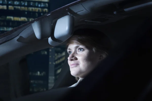 Businesswoman driving at night in the city — Stock Photo, Image