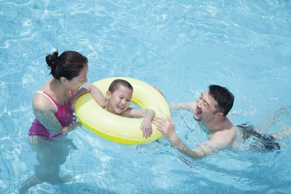 Família brincando na piscina com seu filho — Fotografia de Stock