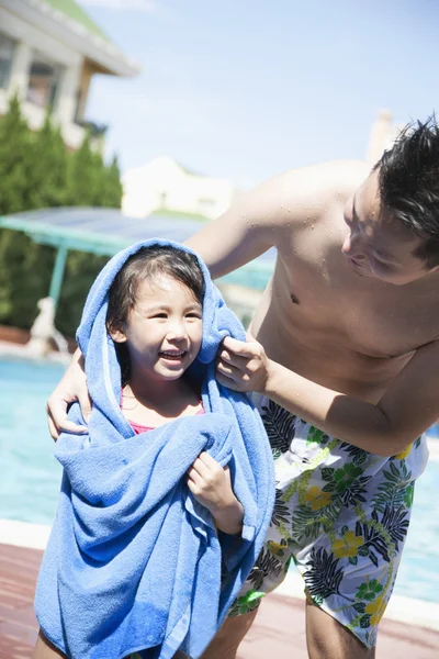 Ojciec wysuszeniu off jego córka z ręcznikiem przy basenie — Zdjęcie stockowe