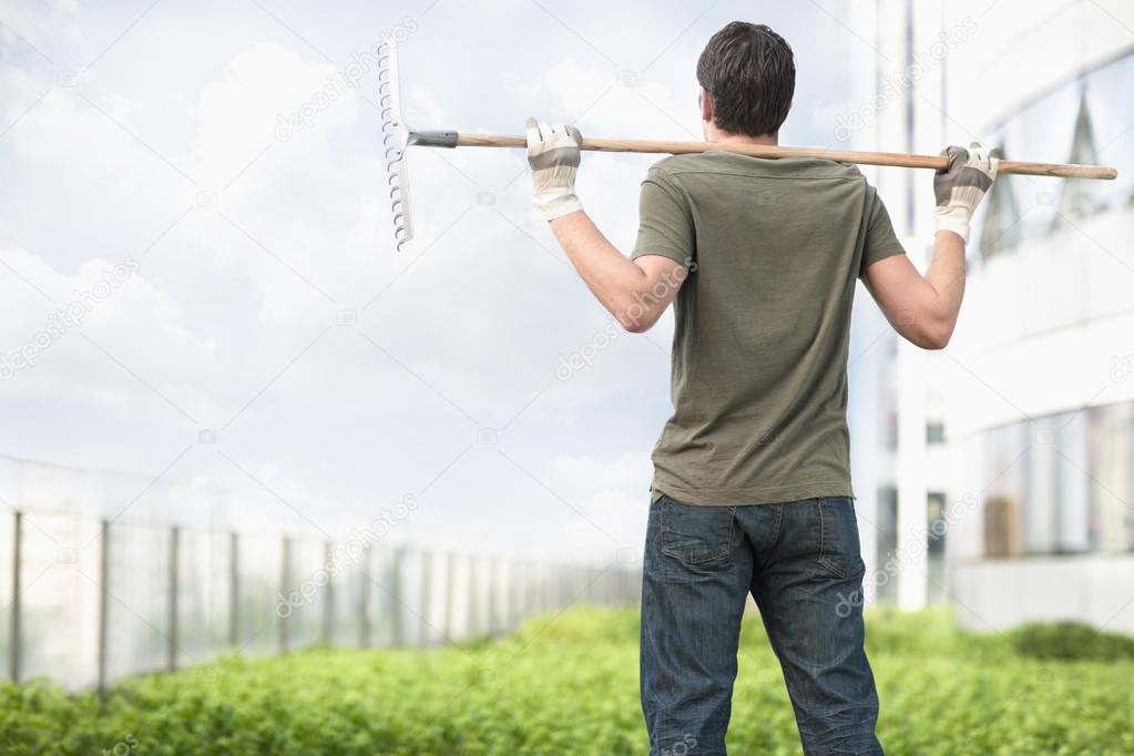 Man holding a rake on his shoulders