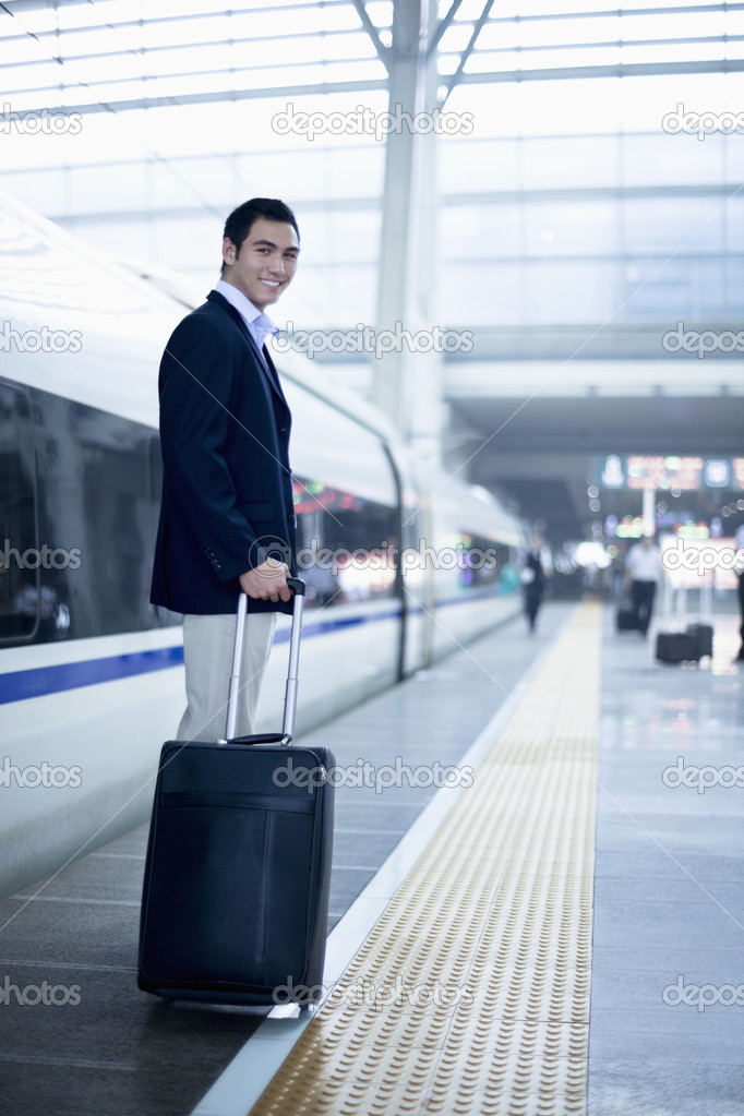 Businessman with a suitcase on the railroad platform