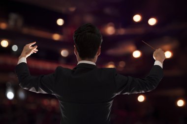 Conductor with baton raised at a performance clipart