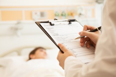 Doctor writing on a medical chart