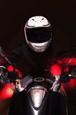 Man riding a motorcycle at night clipart