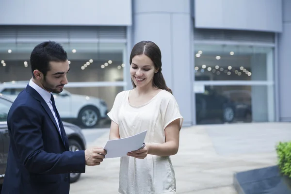 Venditore di auto e giovane donna — Foto Stock