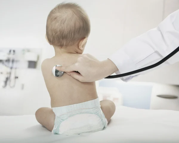 Bebê com os médicos mão verificando batimento cardíaco — Fotografia de Stock