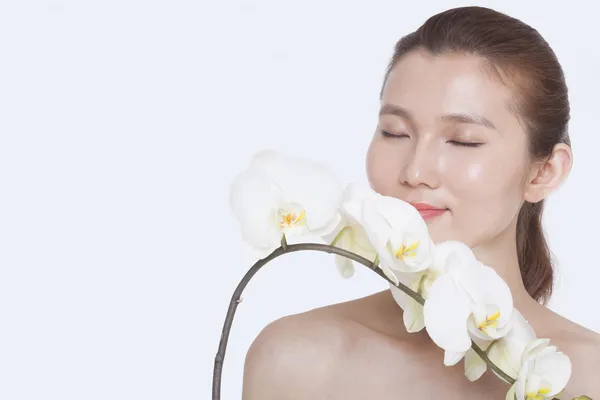 Frau riecht einen Strauß weißer Orchidee — Stockfoto