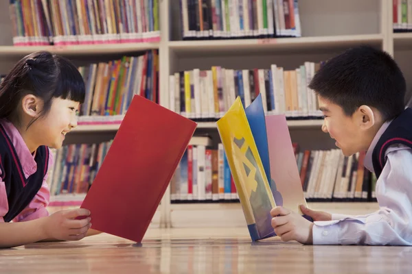 Niños de la escuela leyendo libros en la biblioteca —  Fotos de Stock