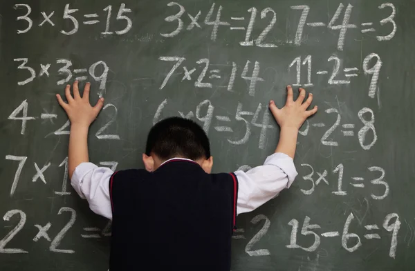 Schoolboy with hands on chalkboard — Stock Photo, Image