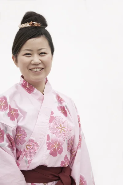 Улыбающаяся женщина в розовом японском кимоно — стоковое фото