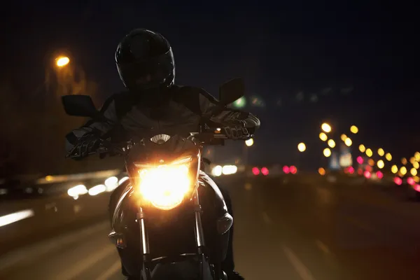 Homem andando de moto à noite — Fotografia de Stock