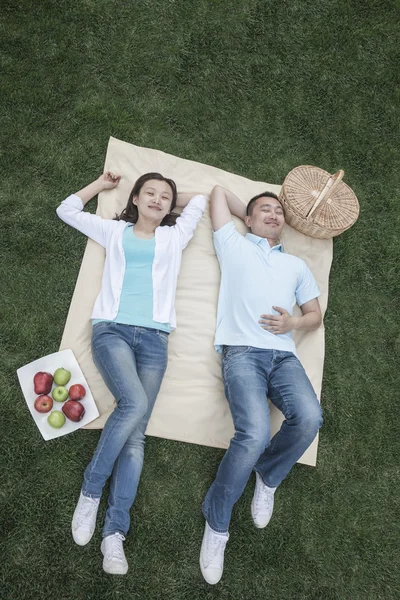 Paar liggend op picknickdeken — Stockfoto