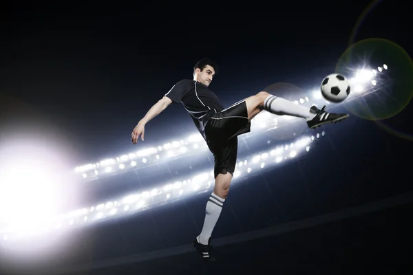 Soccer player in mid air kicking the soccer ball — Stock Photo, Image