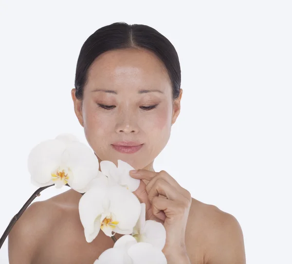 Vrouw aanraken van een stelletje mooie witte orchidee, studio opname — Stockfoto