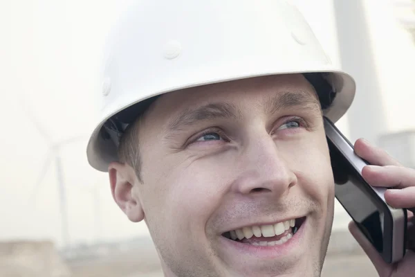 Engineer on the phone beside a wind turbine — Stock Photo, Image