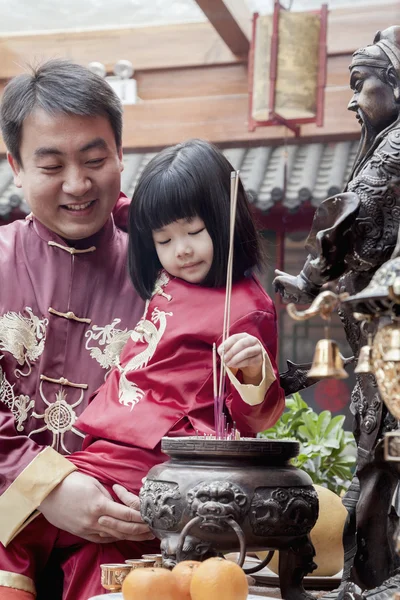 Père et fille offrant de l'encens au temple — Photo