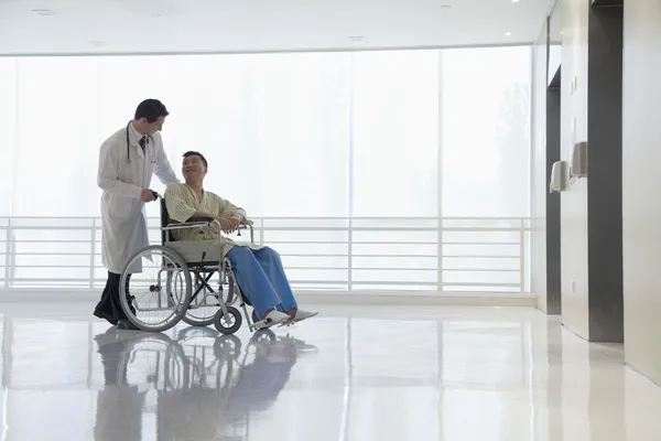 Doctor pushing patient in the hospital — Stock Photo, Image