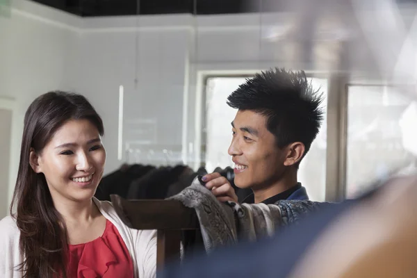 Store clerk showing scarfs to woman — Stock Photo, Image