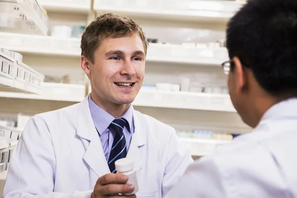 Pharmacist showing prescription medication to a customer — Stock Photo, Image