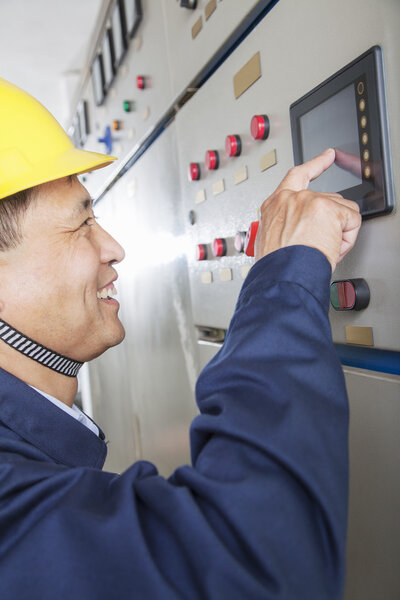 Worker checking controls in a gas plant