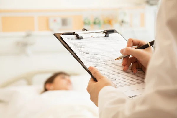 Doctor writing on a medical chart — Stock Photo, Image