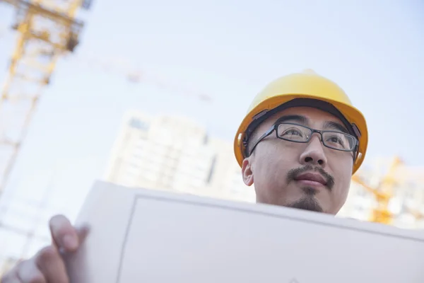 Architect looking at blueprint — Stock Photo, Image