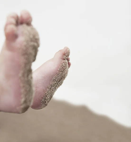 Barnens fötter i sanden — Stockfoto