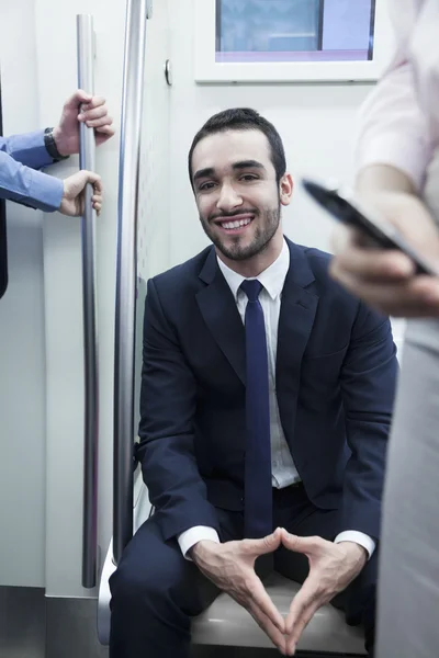 Uomo d'affari sorridente seduto sulla metropolitana — Foto Stock