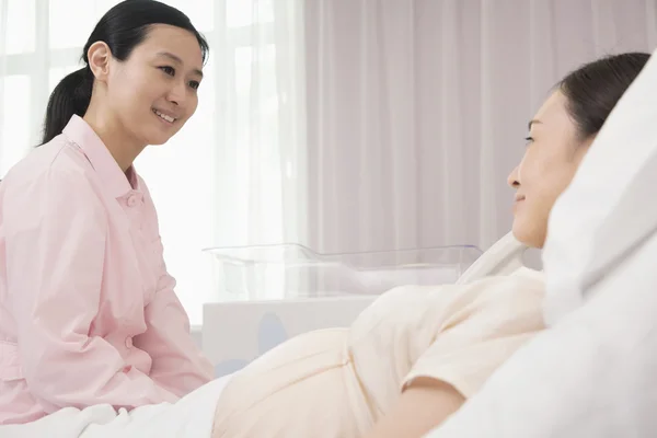 Медсестра разговаривает с беременной женщиной — стоковое фото