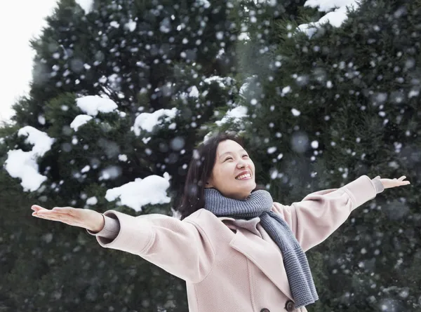 雪の中を感じて両腕を持つ女性 — ストック写真