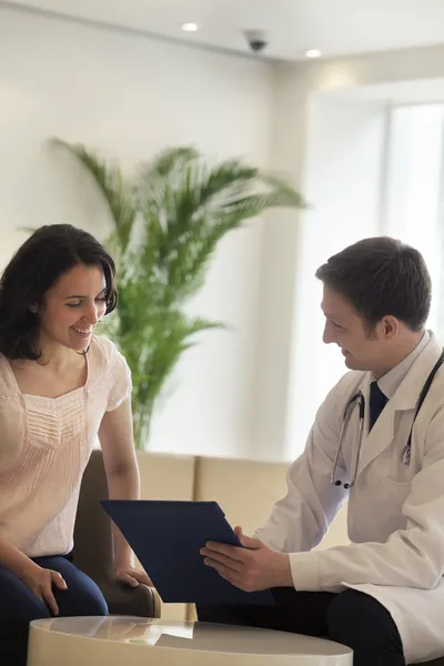 Medico e paziente discutono la cartella clinica — Foto Stock