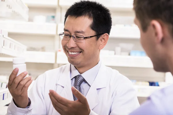 Pharmacist showing prescription medication to a customer — Stock Photo, Image