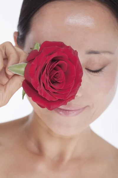 Donna che tiene una rosa rossa agli occhi — Foto Stock