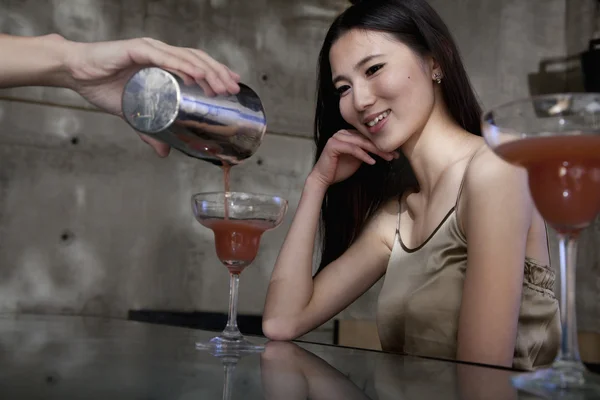 Bartender serving a cocktail to a young woman — Stock Photo, Image